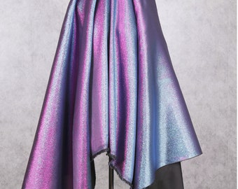 May include: A piece of iridescent fabric with a blue and purple color gradient. The fabric is draped over a stand and has a frayed edge.