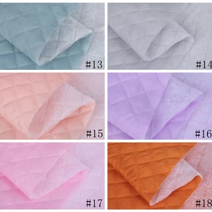May include: Six samples of quilted fabric in different colors: light blue, white, light pink, lavender, pink, and orange. Each sample is labeled with a number from 13 to 18.