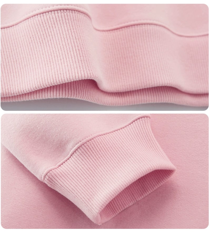 Op de afbeelding: Close-up van de roze geribbelde manchet van een sweatshirt. De stof is zacht en comfortabel.