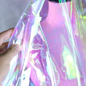 May include: A sheet of iridescent holographic vinyl film with a rainbow of colors, including pink, blue, green, and yellow.