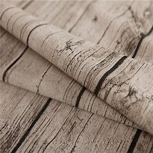 May include: Close-up of a brown fabric with a wood grain pattern. The fabric is folded over, showing the texture and detail of the design.