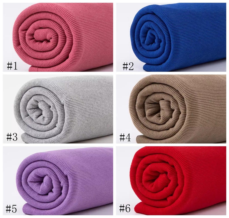 Op de afbeelding: Zes rollen geribbelde stof in verschillende kleuren: roze, blauw, grijs, bruin, paars en rood. De stof is opgerold en de uiteinden zijn zichtbaar.