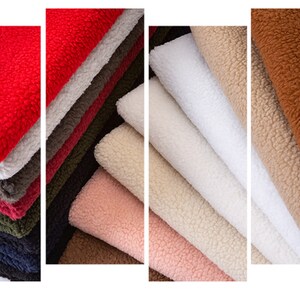 May include: A variety of plush fabrics in different colors, including red, white, brown, and beige. The fabrics are stacked in piles and have a soft, fuzzy texture.