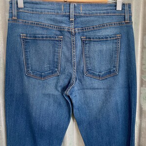 May include: A pair of dark blue denim jeans with two back pockets.
