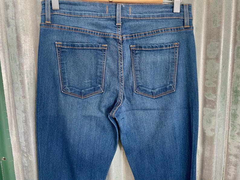 May include: A pair of dark blue denim jeans with two back pockets.