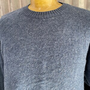 Puede incluir: Un suéter de punto azul con cuello redondo.