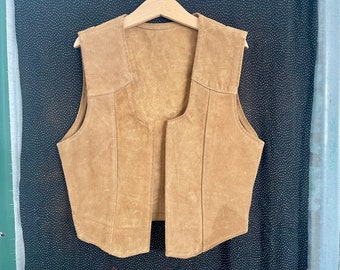 Puede incluir: Un chaleco de ante marrón con cuello en V y un diseño sencillo.