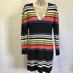 Puede incluir: Un vestido de manga larga a rayas blancas y negras con rayas de colores en rosa, amarillo y azul.