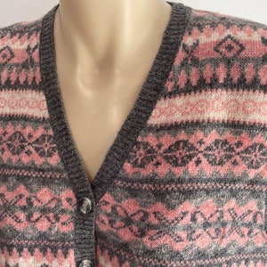 May include: A gray and pink patterned knitted vest with a button closure.