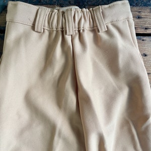 May include: A pair of beige pants with an elastic waistband.