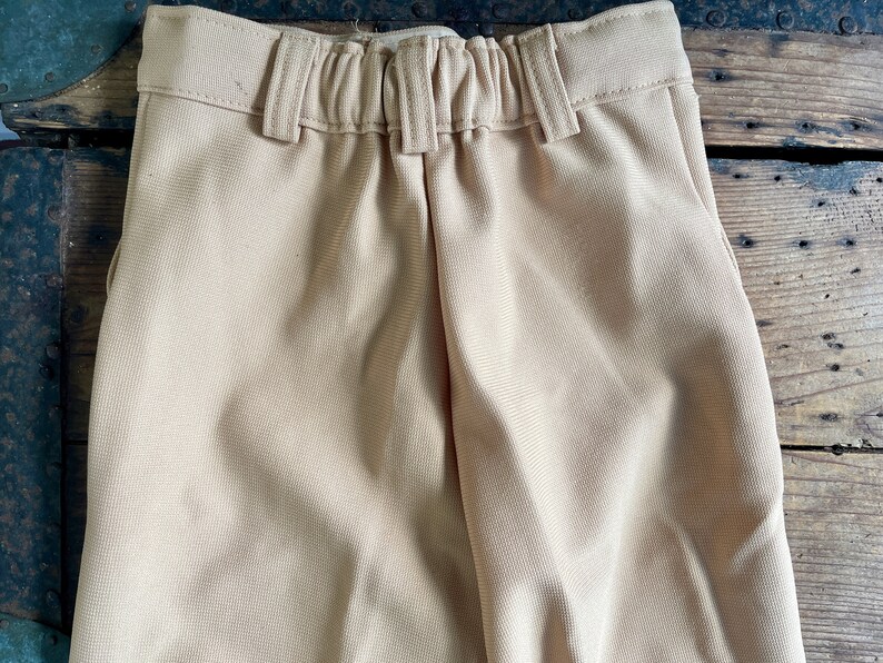 May include: A pair of beige pants with an elastic waistband.