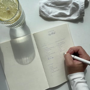 Premium linen pregnancy journal keepsake in soft beige with embossed gold title on a white background GROWING YOU. Hospital bag checklist before giving birth