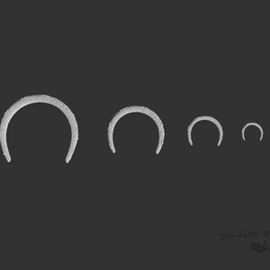May include: Four silver-colored metal hoops of different sizes. The largest hoop has a textured surface.