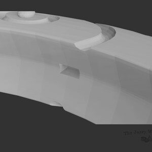 May include: A close-up of a gray, 3D-printed, ring-shaped object with a textured surface and a small, rectangular opening. The object has a series of raised, circular details.