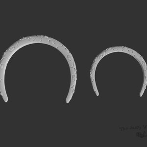 May include: Two white plastic headbands with a decorative eye pattern. The headbands are different sizes.