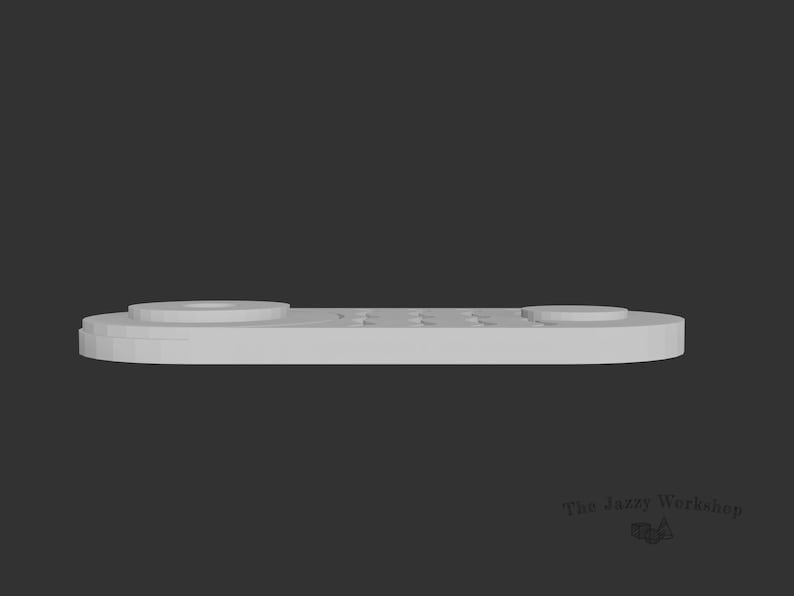 May include: A white plastic remote control with a circular button on the left side and a row of rectangular buttons on the right side.