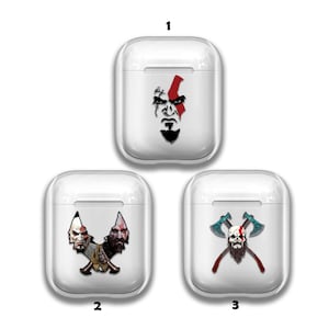Puede incluir: Tres estuches blancos para Airpods con diferentes diseños que presentan al personaje Kratos del videojuego God of War. El primer estuche tiene una imagen en blanco y negro de la cara de Kratos con una barra roja diagonal sobre su frente. El segundo estuche tiene una imagen en blanco y negro de la cara de Kratos con dos hachas cruzadas. El tercer estuche tiene una imagen en blanco y negro de la cara de Kratos con dos hachas cruzadas.