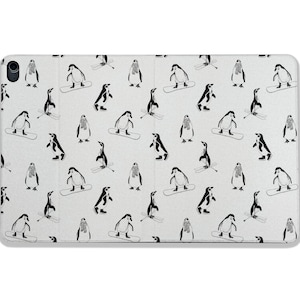 以下が含まれることがあります： 白い携帯電話ケースに、マフラーを巻いてスキーをしている黒いペンギンの繰り返しパターンが描かれています。ペンギンは白い背景に黒いスキーで描かれています。