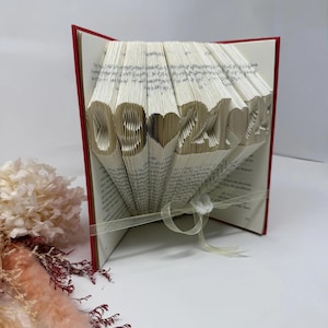 Side view of personalized folded book art featuring a custom date, handmade paper anniversary keepsake.