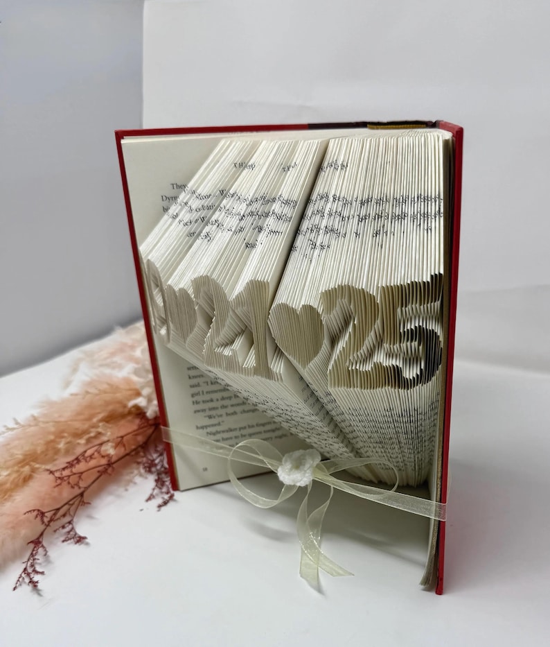 Side view of personalized folded book art featuring a custom date, handmade paper anniversary keepsake.