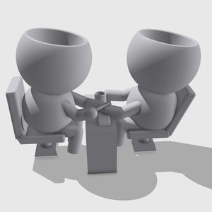 Op de afbeelding: Twee grijze, cartoonachtige figuren die aan een tafel zitten met hun hoofden naar elkaar gekanteld. De figuren hebben grote, ronde hoofden en kleine lichamen. Ze zitten tegenover elkaar en lijken in gesprek te zijn.