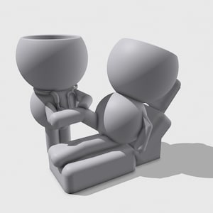 Pu&ograve; includere: Un set di figurine stampate in 3D grigio opaco con due personaggi stilizzati. Una figura &egrave; in piedi con uno stetoscopio, mentre l'altra &egrave; sdraiata orizzontalmente su un lettino da visita rettangolare. Entrambe hanno teste cave a forma di ciotola.