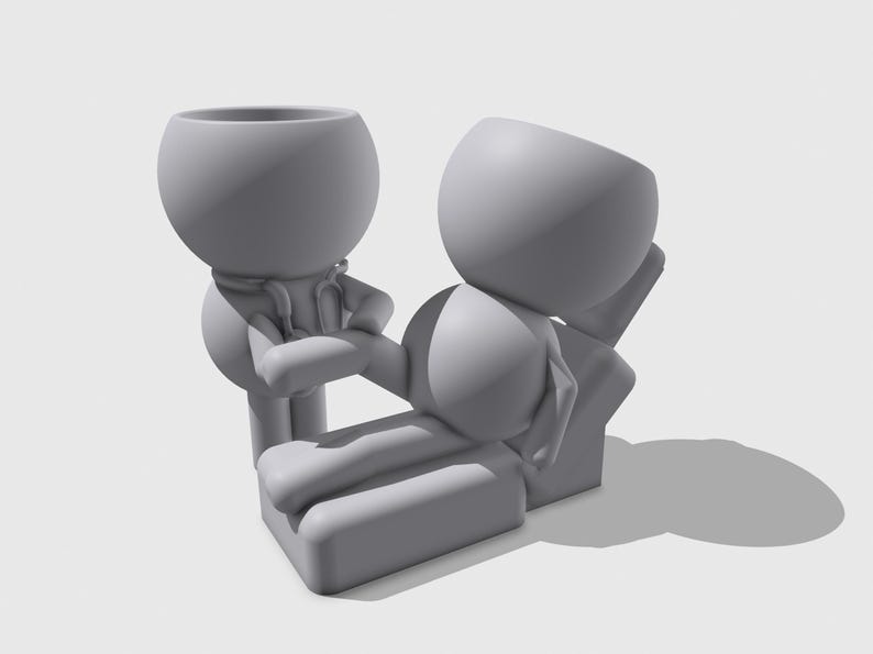 Pu&ograve; includere: Un set di figurine stampate in 3D grigio opaco con due personaggi stilizzati. Una figura &egrave; in piedi con uno stetoscopio, mentre l'altra &egrave; sdraiata orizzontalmente su un lettino da visita rettangolare. Entrambe hanno teste cave a forma di ciotola.