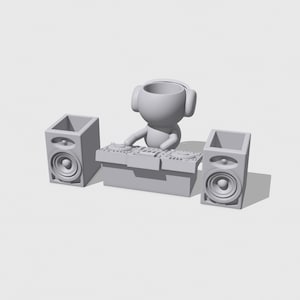 May include: A white figurine of a person wearing headphones and holding a mixer, with two white speakers on either side.