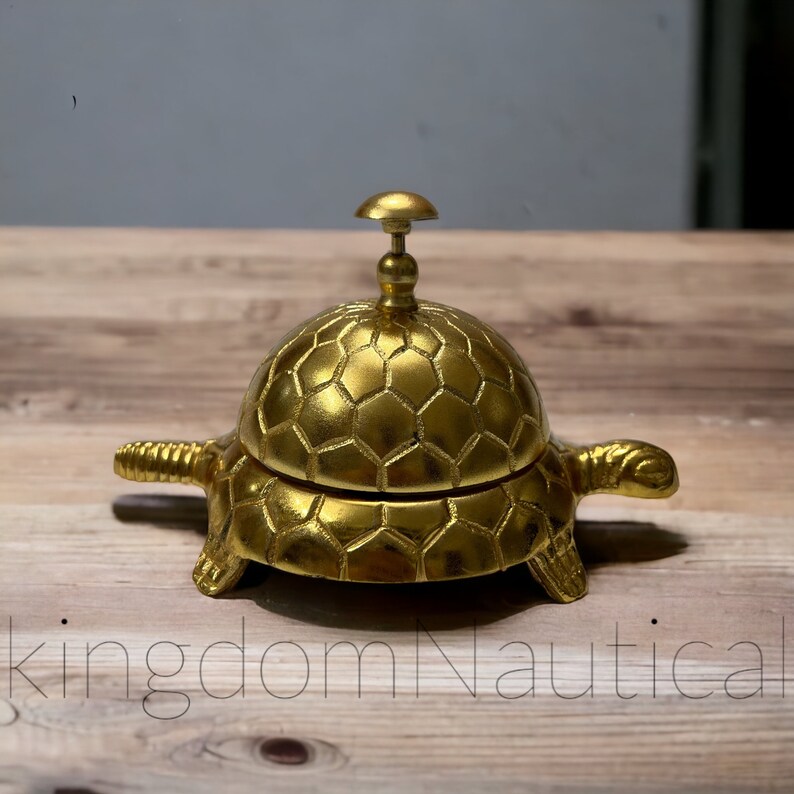 May include: A gold-colored turtle-shaped desk bell with a hexagonal pattern on the shell.