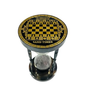 May include: Black and gold hourglass sand timer with a chessboard design on the top. The top of the hourglass has the text "THE CHESS MAKER 6th CENTURY AD" and "SAND TIMER".