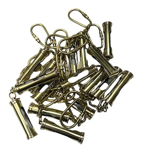 May include: A pile of brass keychains with small hourglass-shaped charms. Each keychain has a brass loop and a small chain.