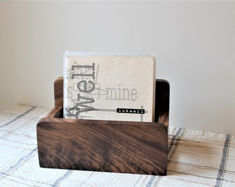 May include: A dark brown wooden magazine holder with a book titled "Well" by "inkwell" inside.