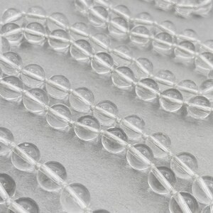 Puede incluir: Una hebra de cuentas de cuarzo transparente, perfectas para hacer joyas o manualidades. Las cuentas son redondas y lisas, con una apariencia transl&uacute;cida.