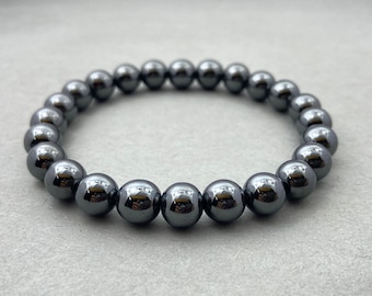 May include: A black hematite beaded bracelet with shiny, round beads.
