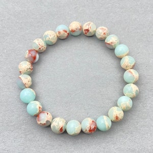 May include: A light blue and brown speckled stone bracelet with 18 beads.