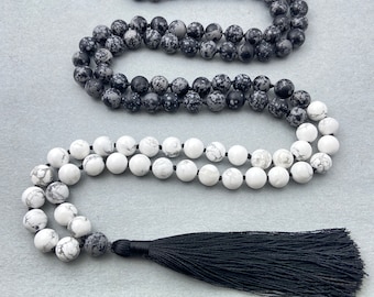 Könnte beinhalten: Eine schwarze und weiße Edelstein-Mala-Halskette mit einem schwarzen Quastenanhänger. Die Halskette besteht aus runden Perlen und hat etwa 108 Perlen.