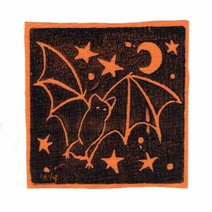 May include: A square print with a Halloween theme, showing a bat with spread wings, a crescent moon, and stars. The design is in orange on a black background, with an orange border. The artwork has a vintage, hand-drawn style.