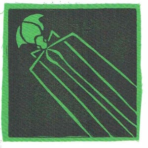 May include: A square fabric patch featuring a black background with a green insect design. The insect has a segmented body and antennae. Diagonal green lines extend from the insect's body. The patch is edged with green fabric.