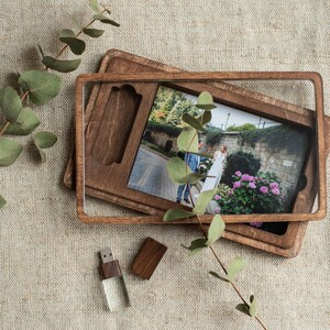 May include: A rectangular dark wood photo box with a clear acrylic lid, containing a printed photograph of a couple in a garden. A matching dark wood USB flash drive with a clear base and a separate wooden cap are positioned nearby.