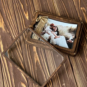 May include: A wooden photo box with a clear glass lid. The box contains a photograph of a couple in a field.
