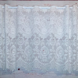 May include: White lace curtain with a floral pattern. The lace is delicate and has a scalloped edge.