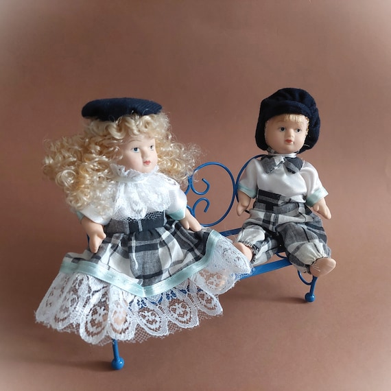Porcelain Dolls Sitting on a Blue Bench; Small Porcelain Dolls