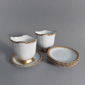 Juego de porcelana Hackefors: 2 palilleros y 5 platos para bolsitas de té. Fabricados en Suecia, pintados a mano con borde dorado.