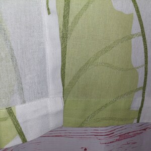 May include: Close-up of a fabric panel featuring a repeating leaf pattern in shades of green and white. The design has a soft, watercolor-like quality. The fabric is likely linen or a similar natural fiber, with a visible weave.