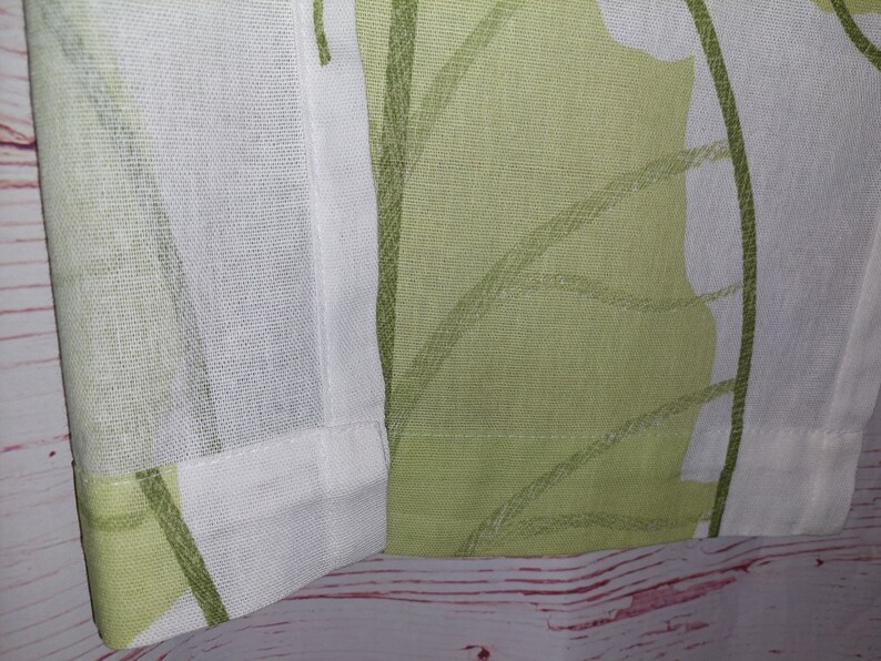 May include: Close-up of a fabric panel featuring a repeating leaf pattern in shades of green and white. The design has a soft, watercolor-like quality. The fabric is likely linen or a similar natural fiber, with a visible weave.