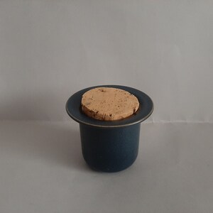 May include: A blue ceramic jar with a cork lid. The jar has a speckled texture.