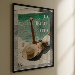 Könnte beinhalten: Ein gerahmtes Poster mit einer Frau im Bikini und einem Strohhut, die am Pool liegt. Der Text "LA DOLCE VITA" ist auf dem Poster gedruckt.