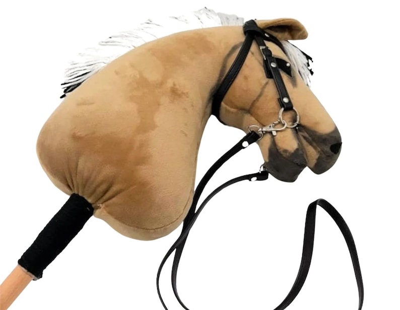 Pu&ograve; includere: Una testa di cavallo di peluche marrone con una criniera bianca e redini in pelle nera. La testa del cavallo &egrave; attaccata a un bastone di legno con un'impugnatura in tessuto nero.