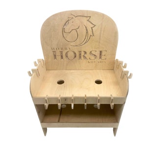 Può includere: Un supporto in legno con un logo a forma di testa di cavallo ritagliato che dice "Hobby Horse Kit Art". Il supporto ha due ripiani con fori per contenere strumenti o altri oggetti.