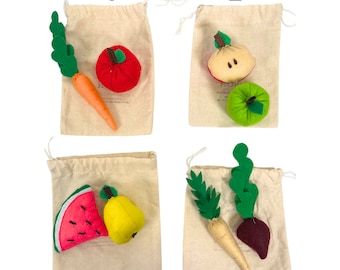 Può includere: Quattro piccole borse di stoffa con giocattoli di feltro a forma di frutta e verdura al loro interno. Le borse sono numerate da 1 a 4. La borsa 1 contiene una mela rossa, una carota e foglie verdi. La borsa 2 contiene una mela gialla, una mela verde e uno stelo marrone. La borsa 3 contiene un'anguria rosa e una pera gialla. La borsa 4 contiene una barbabietola rossa, una carota e foglie verdi.
